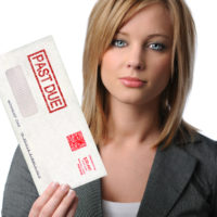 Woman bill collector holding up overdue bills envelope