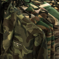 Multiple military jackets hanging on clothes rack Multiple military jackets hanging on clothes rack