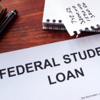 Federal student loan form on a table surrounded by office supplies