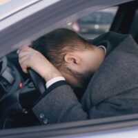 Young bearded business man sitting in car very upset and stressed after hard failure and moving in traffic jam Young bearded business man sitting in car very upset and stressed after hard failure and moving in traffic jam