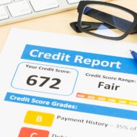 Fair credit score report with pen and keyboard; document is mock