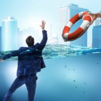 Businessman being saved from drowning Businessman being saved from drowning