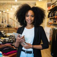 Portrait of the owner of a clothing store at the entrance of the new business with the tablet in hand to analyze the sales, new orders to be sent and check the stocks