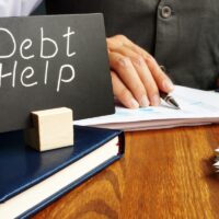 Debt help sign and working man in the office. Debt help sign and working man in the office.