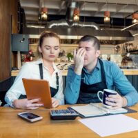 Worried business owners calculating finances - Small restaurant Worried business owners calculating finances - Small restaurant