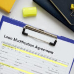 Financial concept meaning Loan Modification Agreement with phrase on the business paper