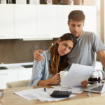 Negative human emotions. Financial problems. Portrait of unhappy young couple having looking worried while reading notification informing them about eviction from apartment because of unpaid bills