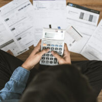 Top view man sitting on the floor stressed and confused by calculate expense from invoice or bill, have no money to pay thinking of taking the house to mortgage causing debt, bankruptcy concept.