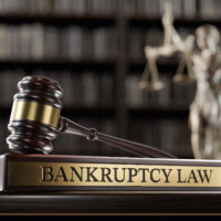 Bankruptcy Law:: Judge's Gavel as a symbol of legal system, Themis is the goddess of justice and wooden stand with text word Bankruptcy Law:: Judge's Gavel as a symbol of legal system, Themis is the goddess of justice and wooden stand with text word